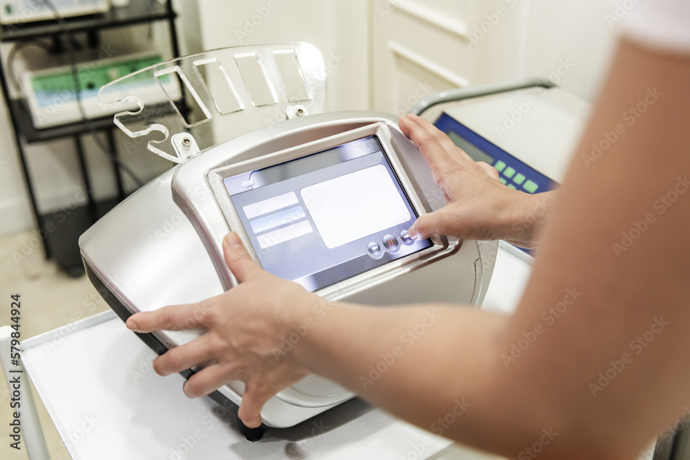 A person programming a device to apply beauty treatments A person programming a device to apply beauty treatments