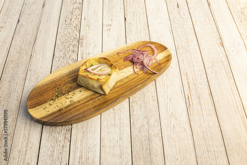 A thin pastry empanada stuffed with cheese and plenty of red onion