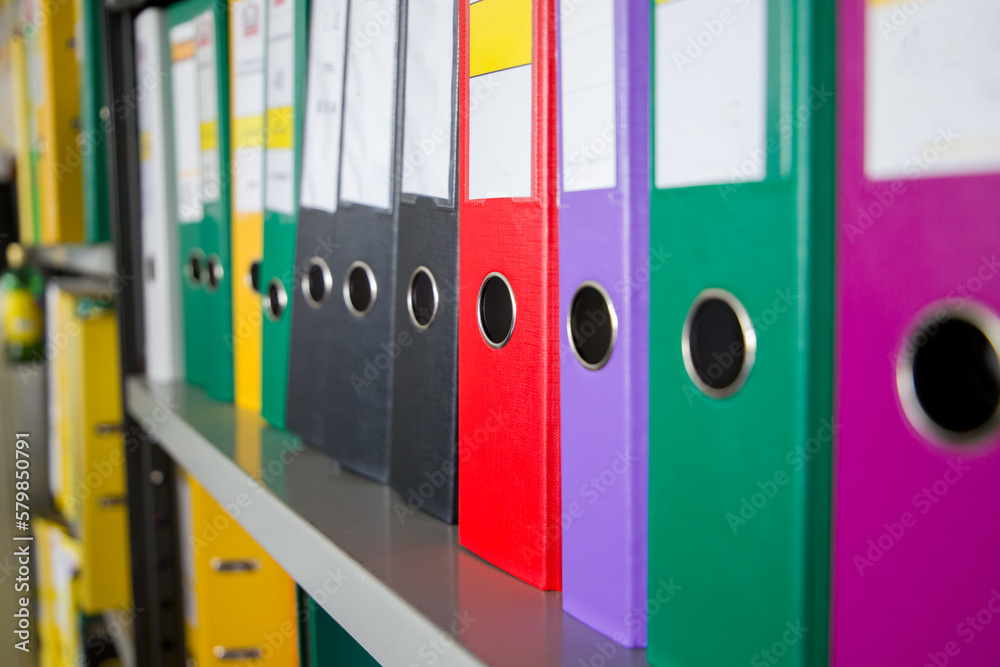Office folders on the shelves in the office. Selective focus.