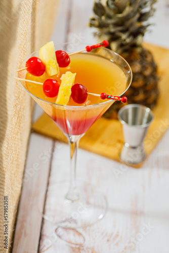 Bikini martini cocktail in martini glass garnished with cherries and pineapple. Martini alcoholic cocktail or non-alcoholic mocktail. Martinis.
