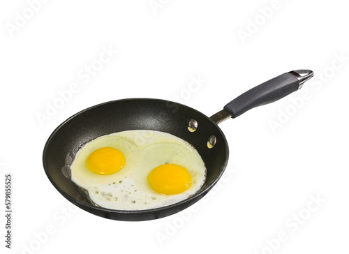 Eggs sunny side up cooking in frying pan with cut out background.