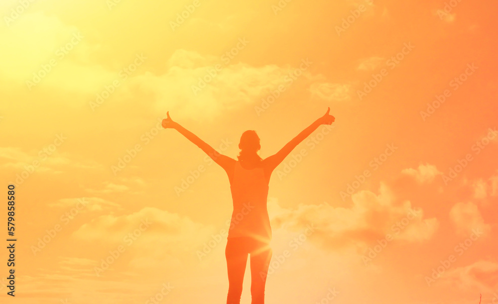 Young female feeling grateful, positive, joyful standing outdoors in the sunrise Young female feeling grateful, positive, joyful standing outdoors in the sunrise