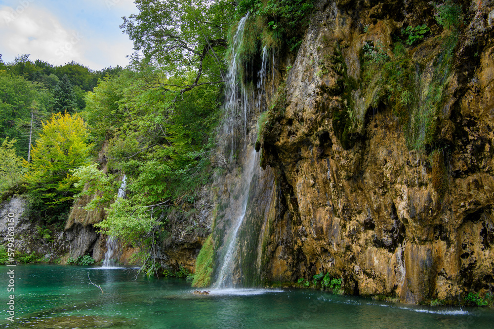 Fototapeta premium Plitvice, Croatia: View of the beautiful waterfalls of Plitvice Lakes in Plitvice National Park. Green foliage and turquoise water