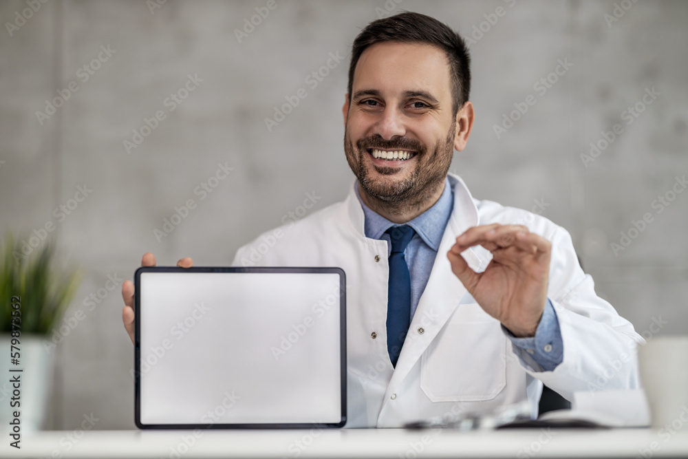Portrait of male doctor holding digital tablet and showing free space Portrait of male doctor holding digital tablet and showing free space