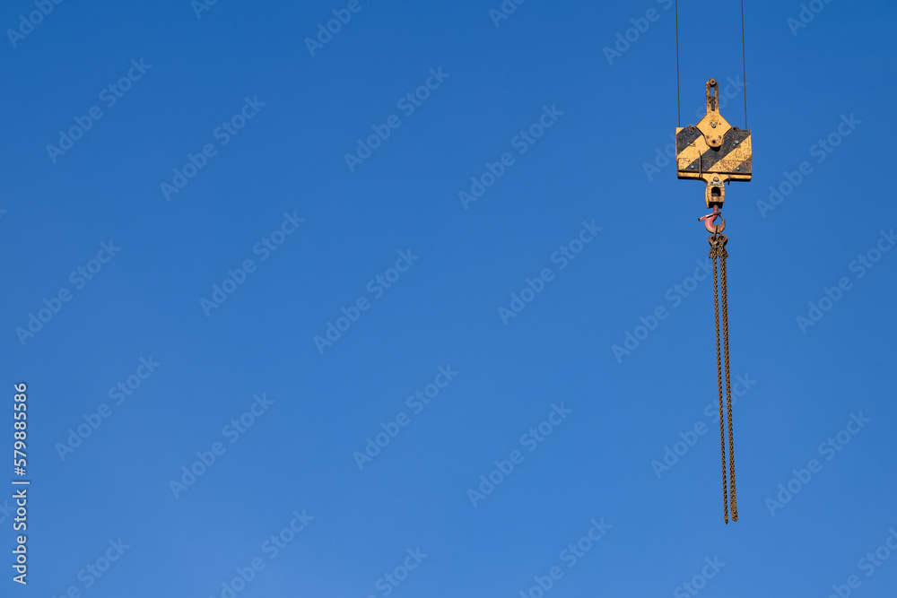 Steel chains on the hoist of a construction crane, isolated, copyspace Steel chains on the hoist of a construction crane, isolated, copyspace