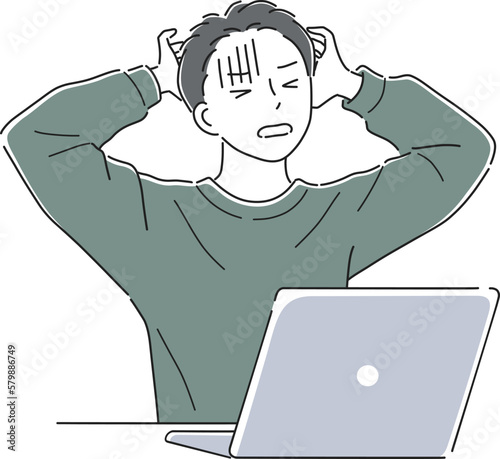 ノートパソコンの前で頭を抱える男性
