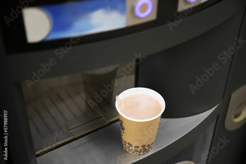 Coffee and hot beverage vending machine with paper cup on drip tray, above view