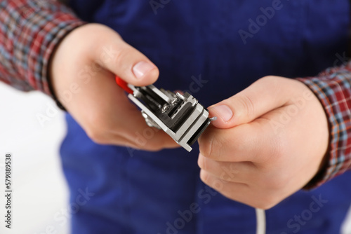 Professional electrician stripping wiring on white background, closeup