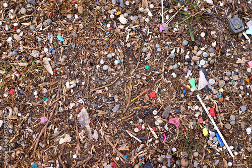 Micro plastic waste mixed with soil. Small piece of plastic garbage that is difficult to clean in nature. Image of soil contaminated with micro plastic waste.