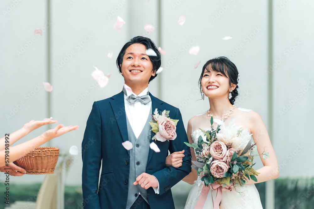 Φωτογραφία 結婚式でフラワーシャワーを浴びる新郎新婦と祝うゲスト