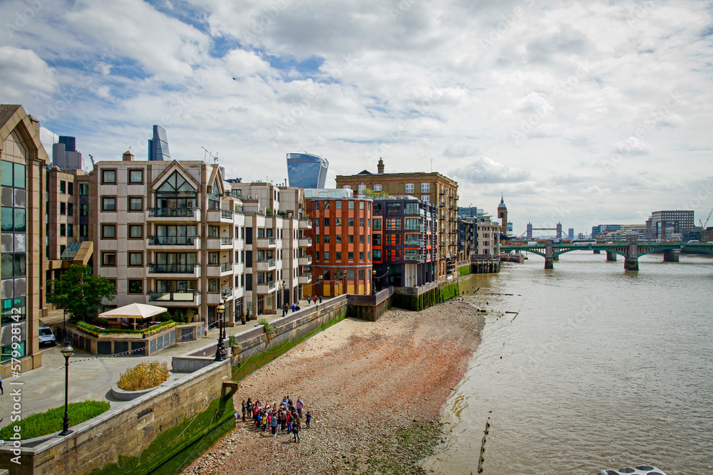 Thames River in London at low tide with brightly colored buildings
