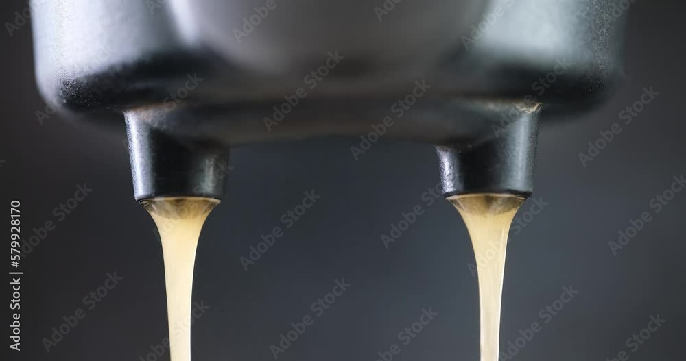 making espresso - Flowing fresh ground coffee stream from professional machine Close up making espresso - Flowing fresh ground coffee stream from professional machine Close up