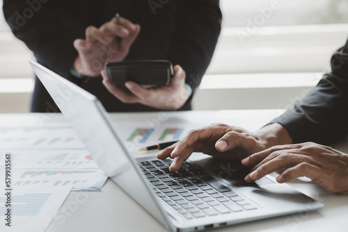 Foto Person typing on laptop keyboard, businessman working on laptop, he is typing messages to colleagues and making financial information sheet to sum up the meeting