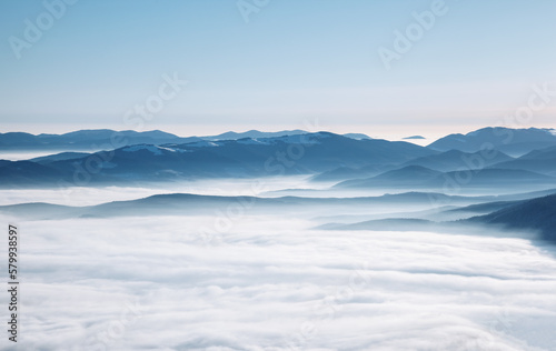 Sunny frosty day in the mountains with fog in the valley. Carpathian, Ukraine, Europe.