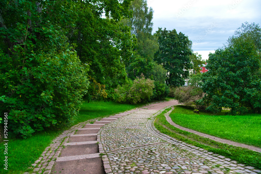 Path in green meadow and trees in Park Mon Repos, Vyborg, Russia