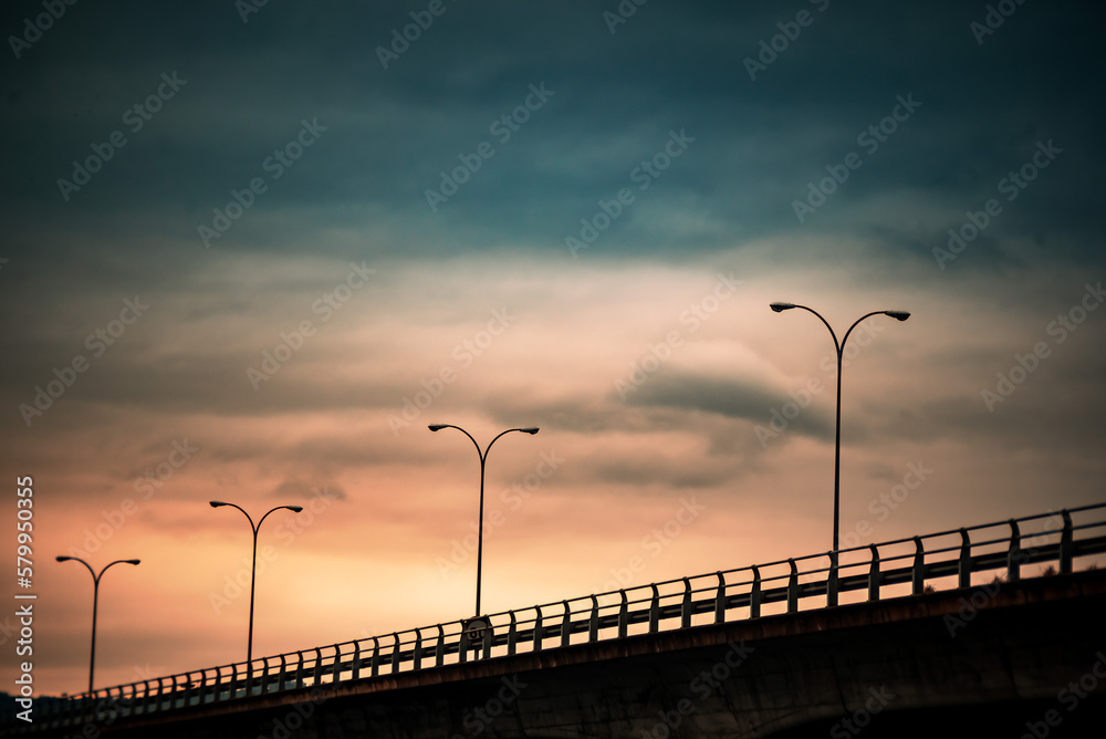 Golden Gateway: Bridge Under Cloudy Sunset Sky