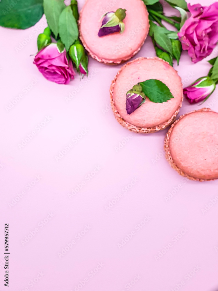 French macaroons cake. Selective focus of delicious pink macaroons with pink baby rose flowers on white background. French macaroons cake. Selective focus of delicious pink macaroons with pink baby rose flowers on white background.