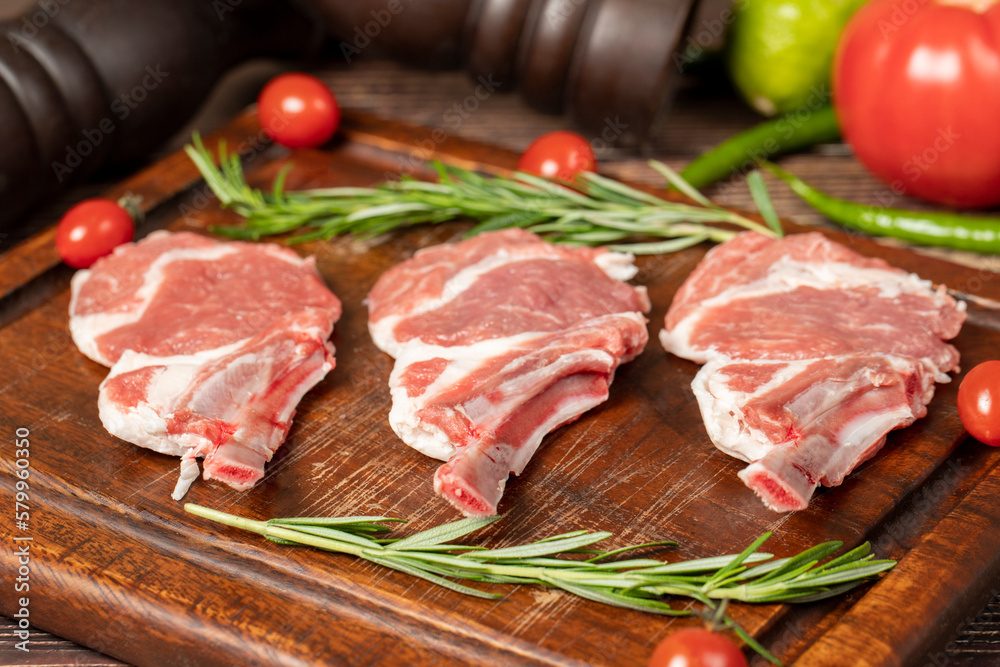 Raw lamb chops. Fresh raw lamb chops with spices and herbs. Wood background. Close up