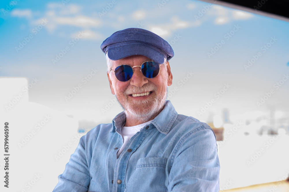 Portrait of senior man smiling and looking at camera. Face of a happy old man wearing blue sunglasses and cap outdoor. Retired relaxed man with white hair and beard in denim shirt Portrait of senior man smiling and looking at camera. Face of a happy old man wearing blue sunglasses and cap outdoor. Retired relaxed man with white hair and beard in denim shirt