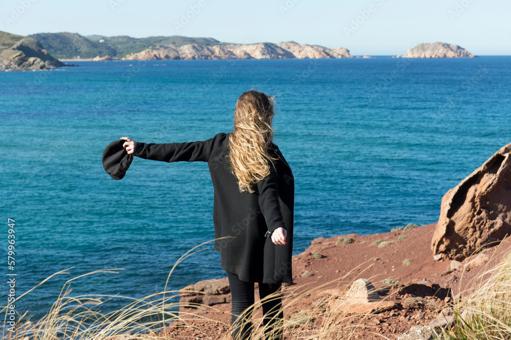 Young woman looking at view while standing on shore Young woman looking at view while standing on shore