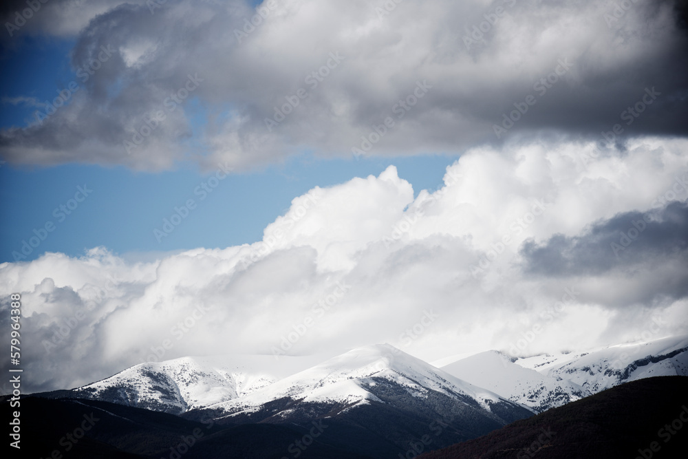Low angle view of snowcapped mountains against cloudy sky Low angle view of snowcapped mountains against cloudy sky