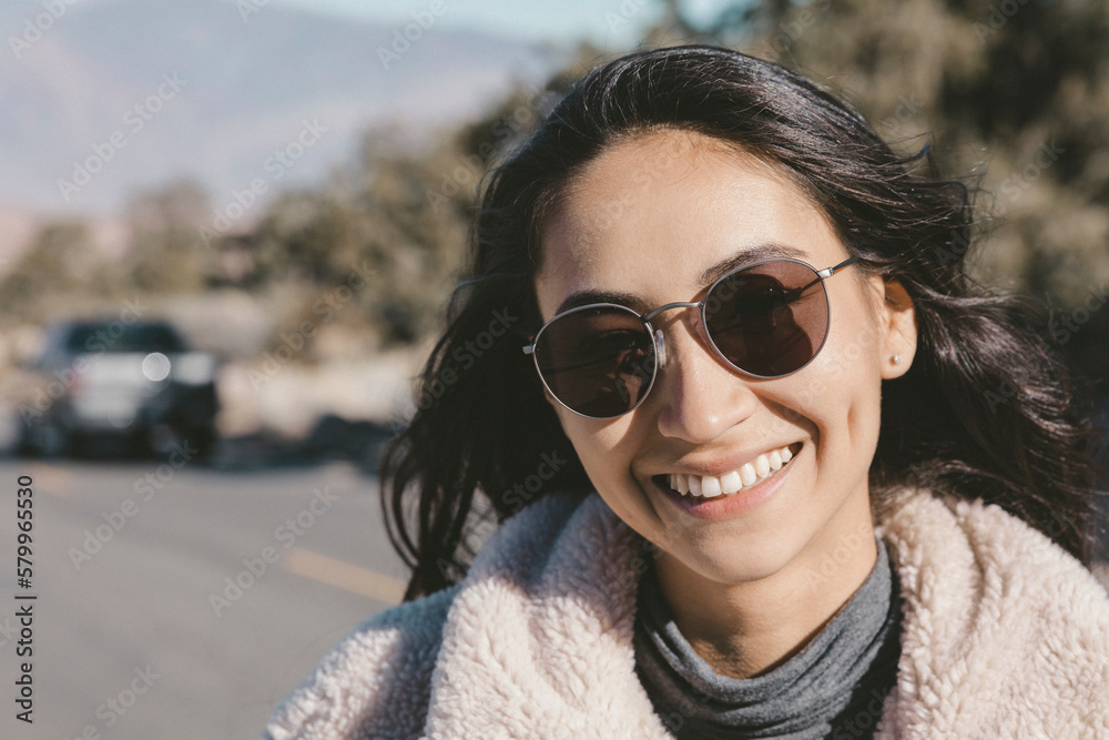 Close-up portrait of smiling young woman wearing sunglasses on road Close-up portrait of smiling young woman wearing sunglasses on road