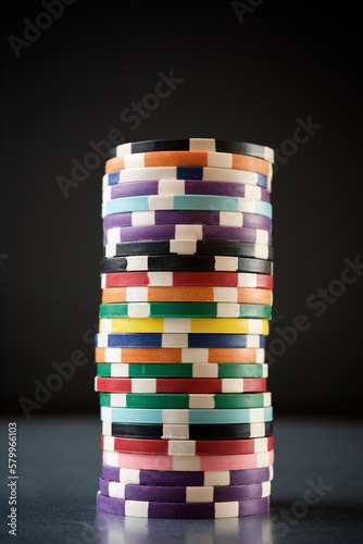 Close-up of colorful gambling chips arranged on table against black background photo