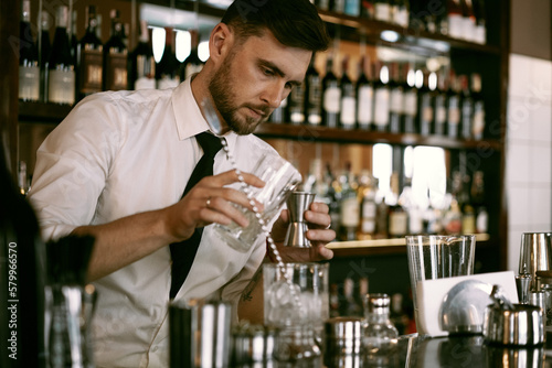 A young man bartender works in a bar made a cocktail. photo