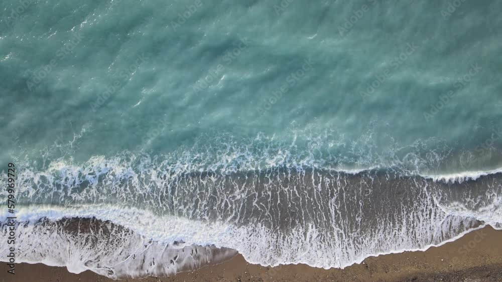 plage de galets en vue aérienne	avec le ressac des vagues