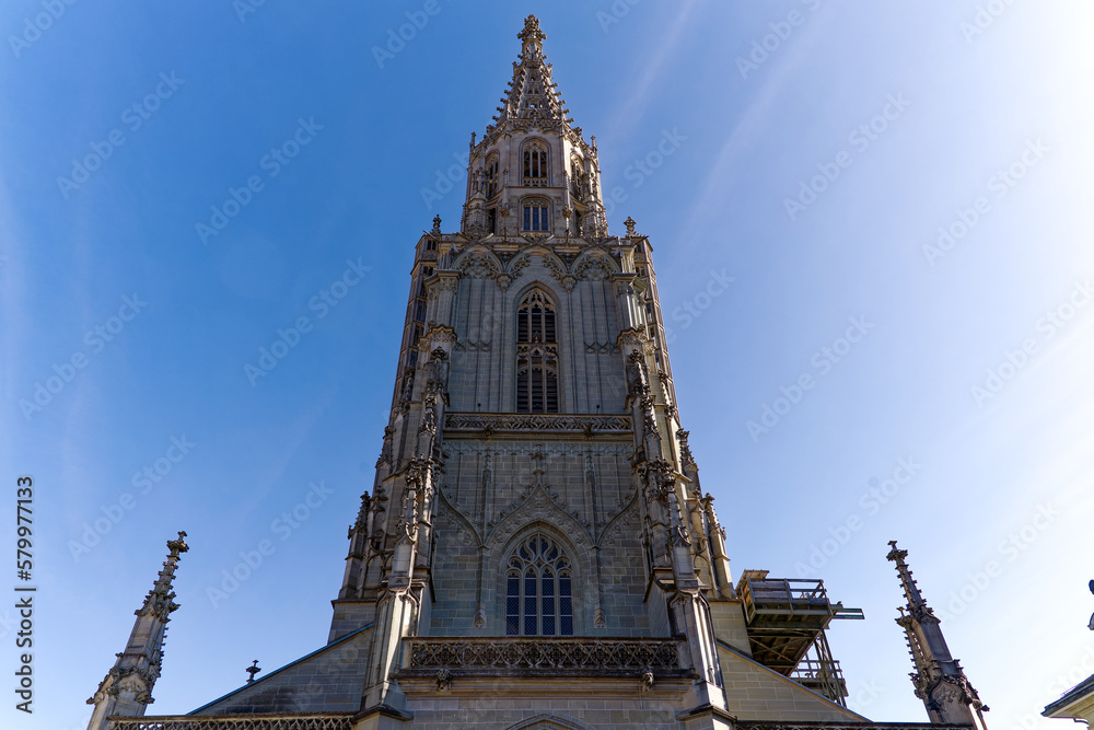 Fototapeta premium Looking up tower of Berner Münster church at the old town of City of Bern on a sunny winter day. Photo taken February 21st, 2023, Bern, Switzerland.