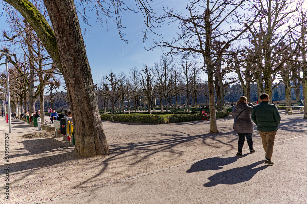 Scenic view of tree alley at Minster Terrace at the old town of Swiss City of Bern with tourists on a sunny winter day. Photo taken February 21st, 2023, Bern, Switzerland.