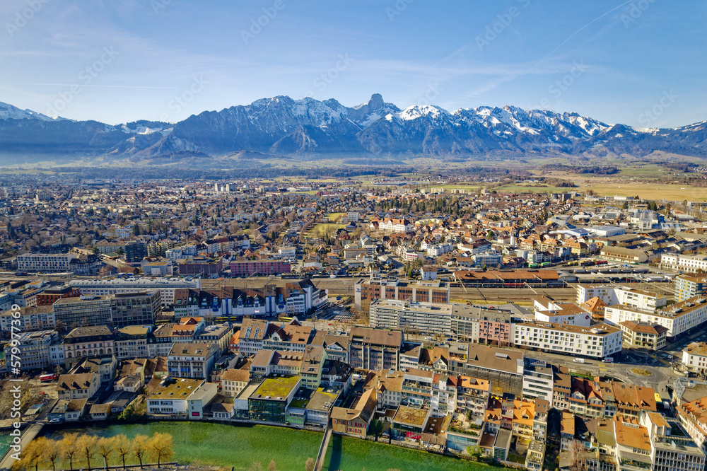 Aerial view of City of Thun with railway station and beautiful mountain panorama with peak Stockhorn on a sunny winter day. Photo taken February 21st, 2023, Thun, Switzerland.