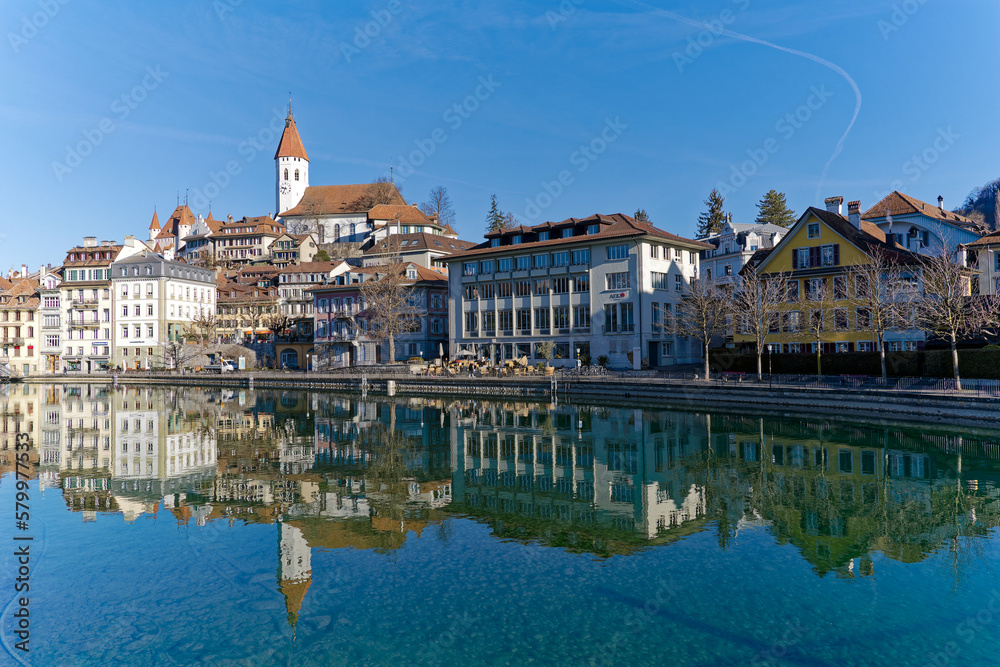 Scenic view of Aare River with the old town of Swiss City of Thun and castle and church on a hill on a sunny winter day. Photo taken February 21st, 2023, Thun, Switzerland.