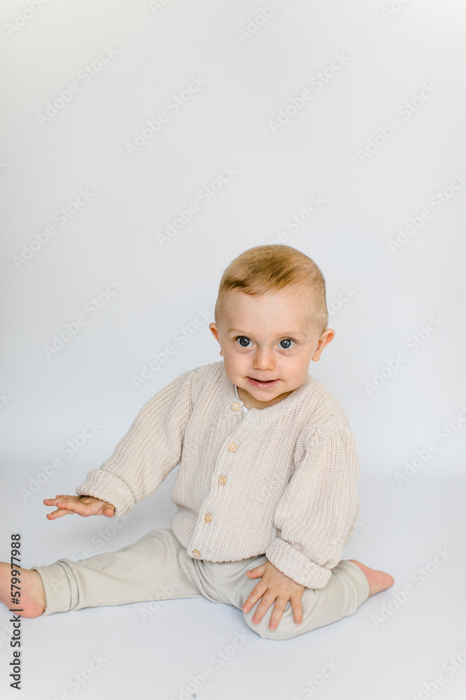 Fototapeta premium Kleiner Junge sitzt und lacht fröhlich