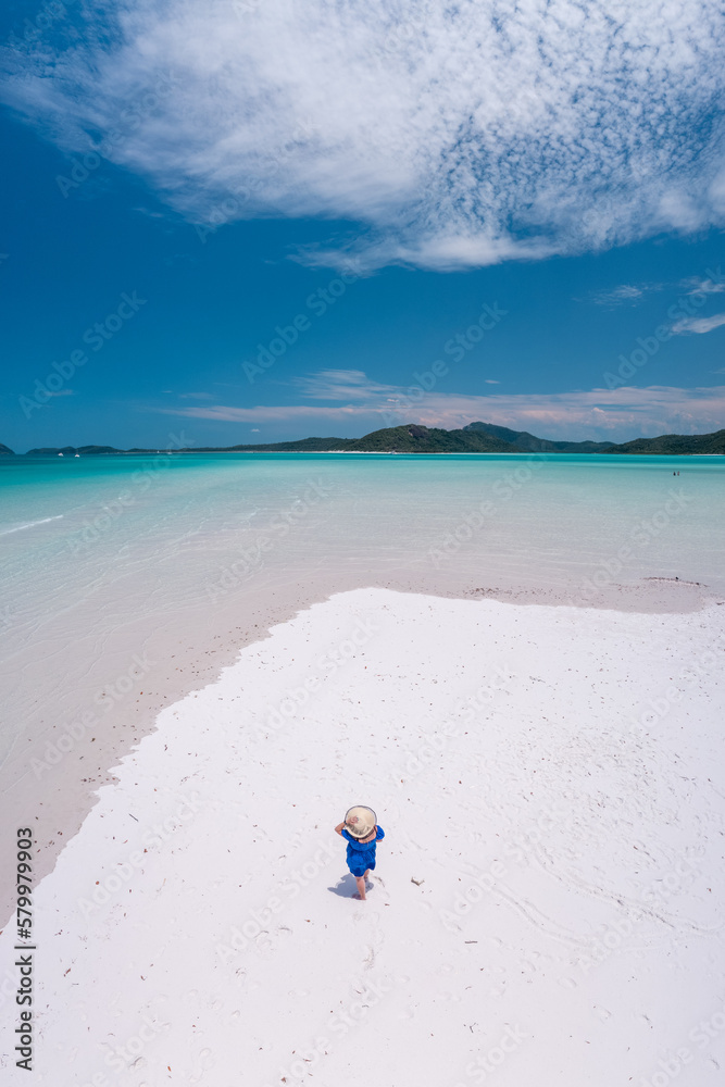 Aerial view of a woman standing on the beautiful Whitehaven  Beach in the Whitsundays