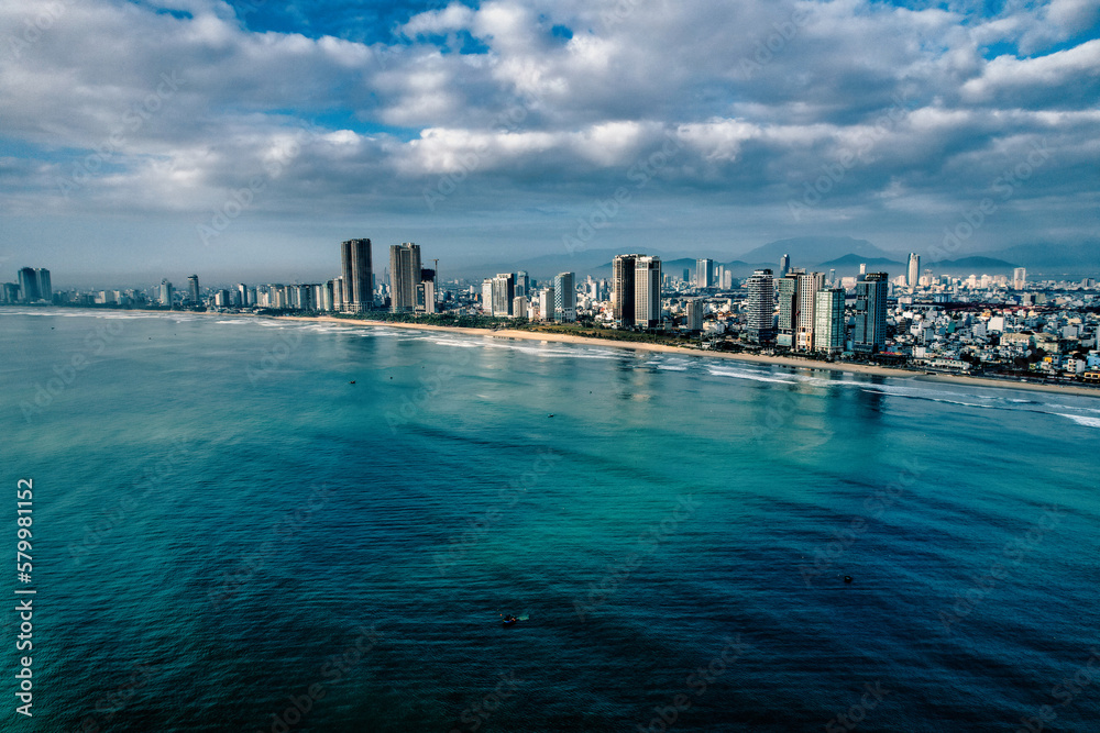 Coastline of Da Nang Vietnam in the morning, skyscrapers with clouds in the sky and stunning blue green color in the sea 