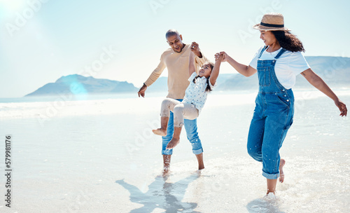 Family, beach and mother and father with girl playing for bonding, quality time and adventure together. Travel, happy and mom, dad and child enjoy summer holiday, vacation and relax on weekend by sea #579981176