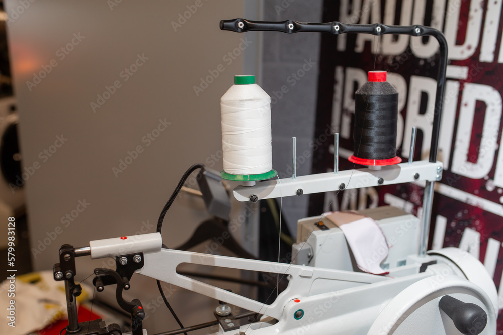Industrial sewing machine with black and white thread spools Industrial sewing machine with black and white thread spools