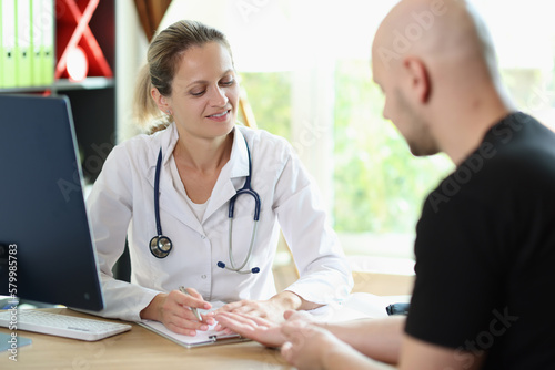 Female doctor is talking to her patient in medical clinic office.