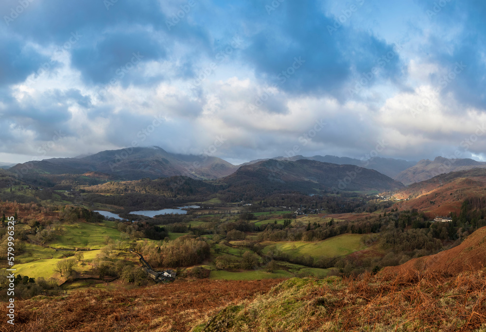 Stunning Winter sunrise golden hour landscape view from Loughrigg Fell across the countryside towards Langdale Pikes in the Lake District