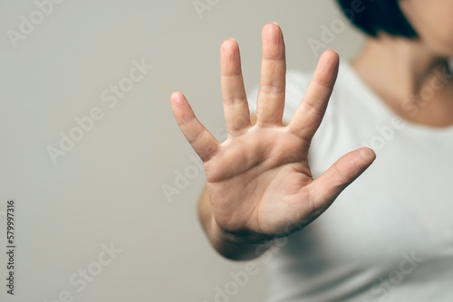 Gender based violence concept: woman stretches her arm to try to stop an attack