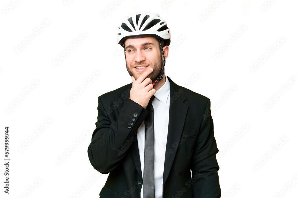 Business person with a bike helmet over isolated chroma key background thinking an idea while looking up Business person with a bike helmet over isolated chroma key background thinking an idea while looking up