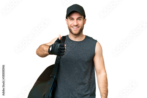 Young sport man with sport bag over isolated chroma key background with thumbs up because something good has happened