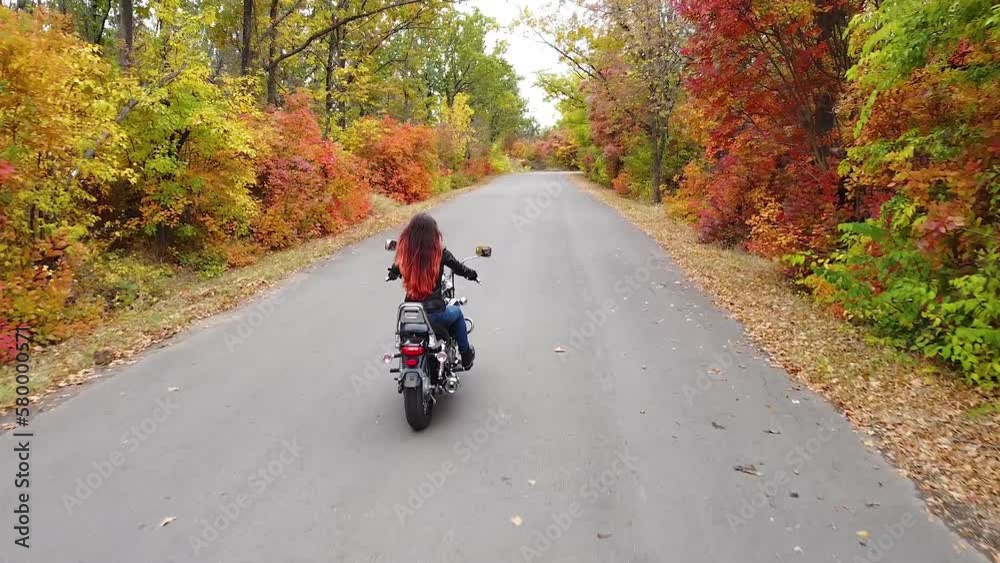 Young Woman With Long Hair Rides A Motorcycle On An Autumn Forest Road Young Woman With Long Hair Rides A Motorcycle On An Autumn Forest Road