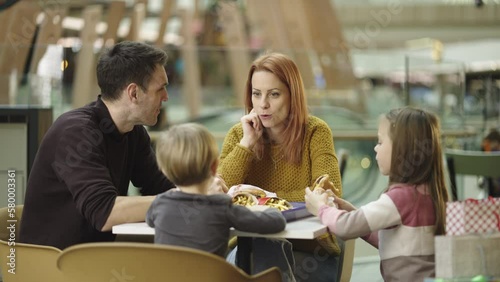 Wallpaper Mural Cheerful parents and kids eating together and talking with each other at caf� in shopping mall. Shot in slow-motion Torontodigital.ca