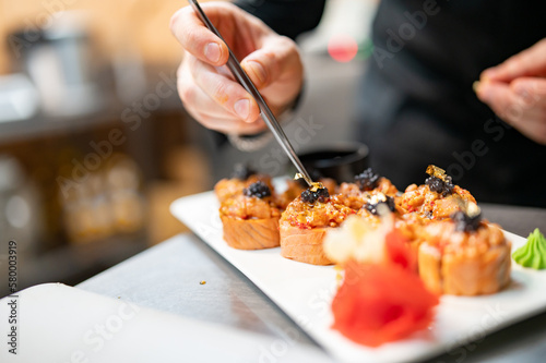 professional chef's hands making sushi and rolls in a restaurant kitchen