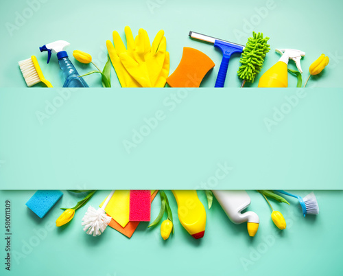 Flat lay composition with cleaning supplies, tools and spring flowers on colorful background