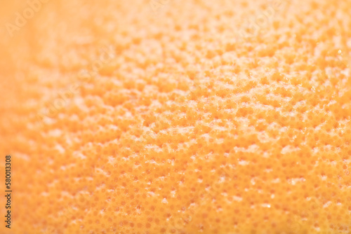 Defocused and blurred grapefruit orange skin macroclose up with pores