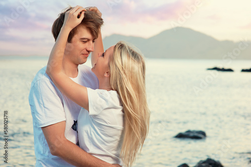 Love and romance. Honeymoon on the sea shore. Beautiful loving couple embracing on the beach