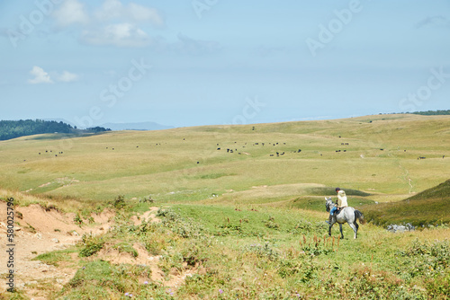 An unrecognizable man on a horse in the mountains. Protection of the National Park